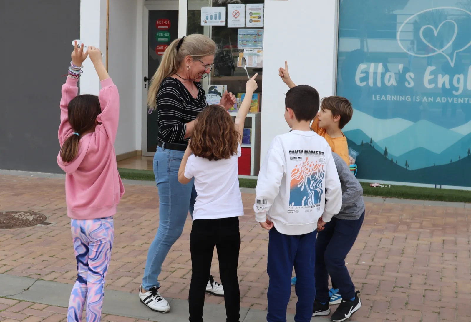 Una profesora y alumnos delante de la entrada de la academia