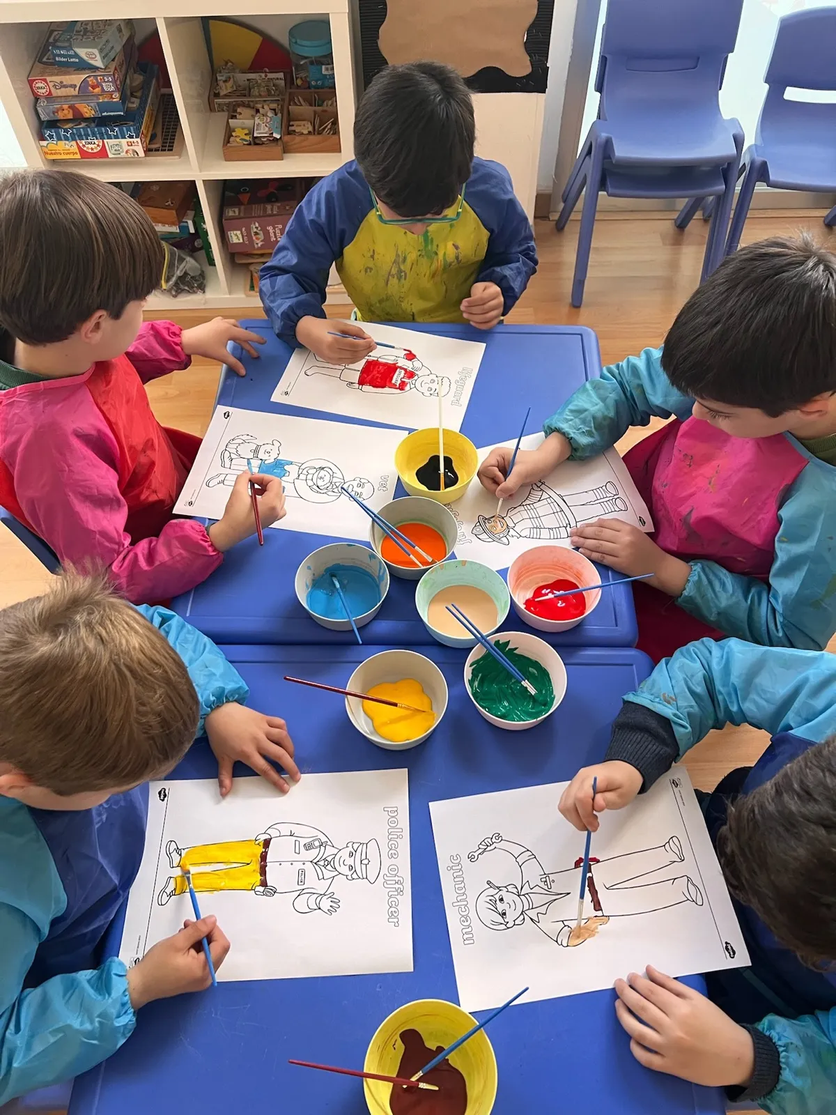 Niños pintando juntos alrededor de una mesa